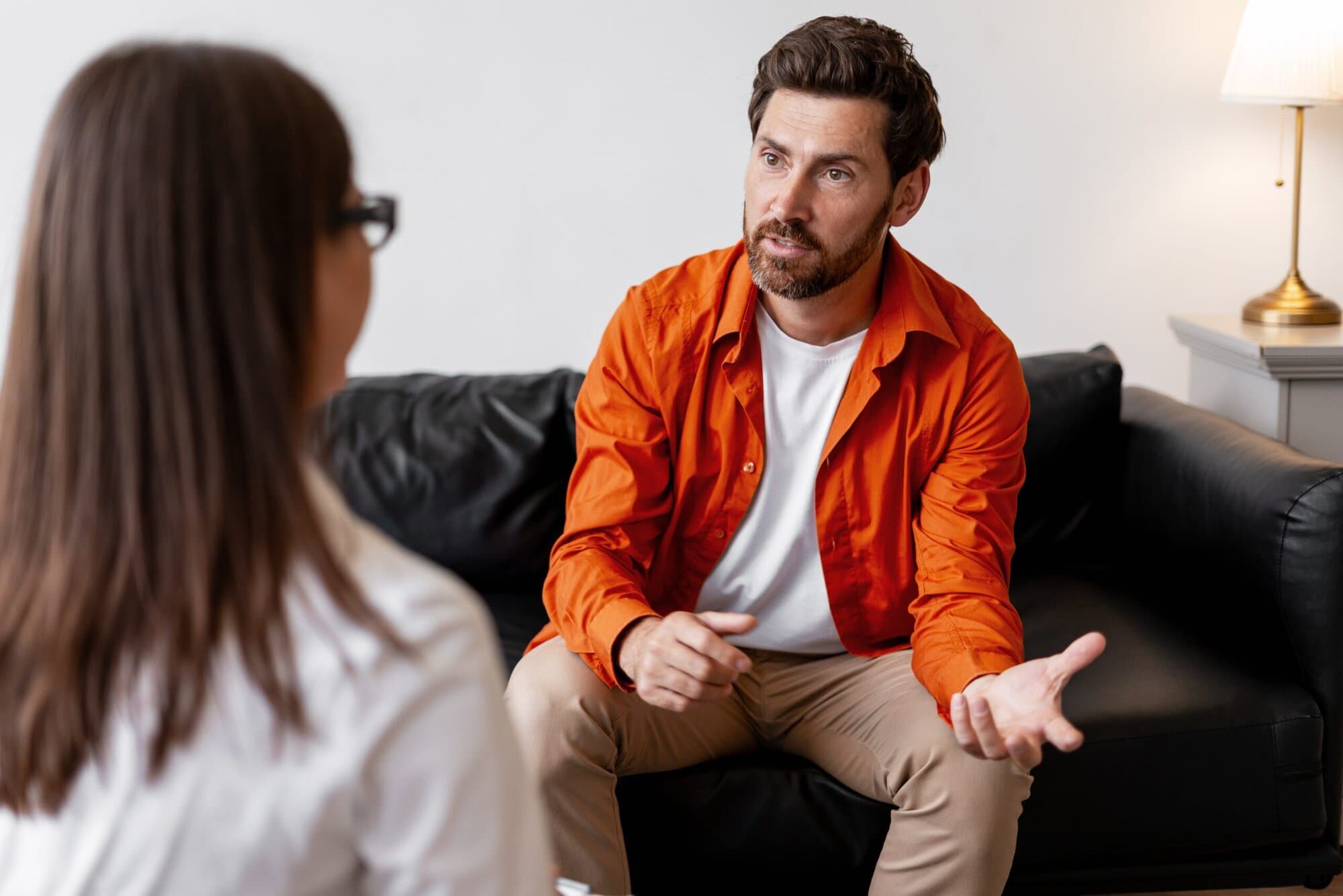 Man sitting on couch talking to therapist