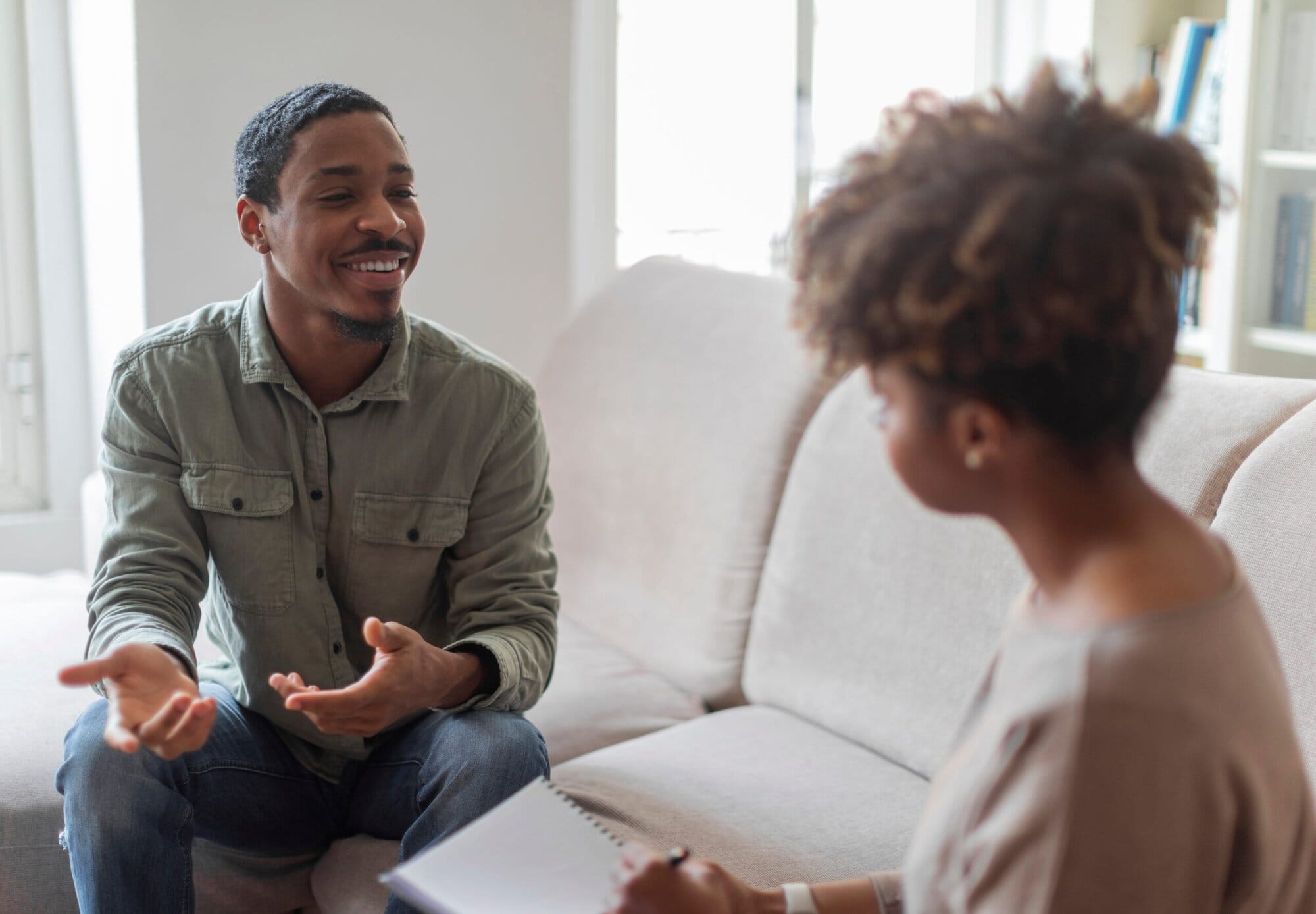 Man sitting on couch talking to therapist